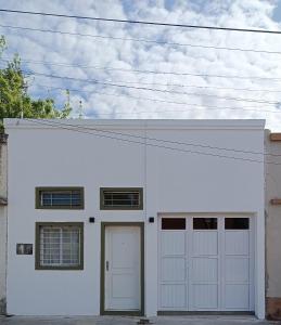 Un garaje blanco con dos puertas blancas. en Caá Guazú, en Curuzú Cuatiá