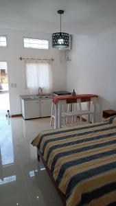 Habitación con mesa y cocina con cama en Caá Guazú, en Curuzú Cuatiá