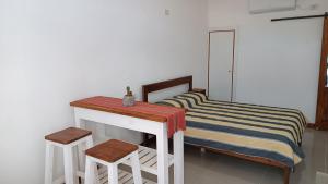 a bedroom with a bed and a table and two stools at Caá Guazú in Curuzú Cuatiá