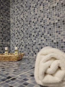 La salle de bains est pourvue d'une serviette au sol et d'un mur carrelé. dans l'établissement Haza Del Puente, à Riópar