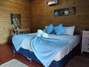 1 dormitorio con 1 cama en una habitación de madera en Posada Las Maravillas, en Punta del Diablo