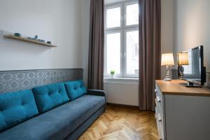 a living room with a blue couch in front of a window at Near the Royal Castle in Krakow