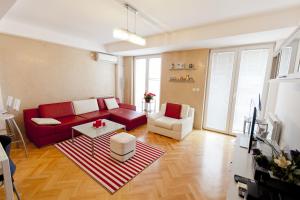 a living room with a red couch and a table at Tina Apartments in Skopje