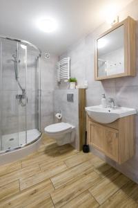 een badkamer met een wastafel, een douche en een toilet bij Near the Royal Castle in Krakau