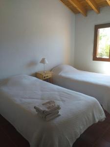 a bedroom with two beds with towels on the bed at Bella Vista in Potrerillos
