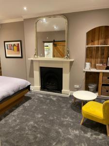 a bedroom with a bed and a mirror and a fireplace at Canty’s 