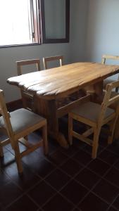 a wooden table and chairs with a wooden table and a table and chairs at Bella Vista in Potrerillos