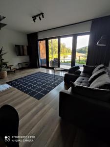 a living room with a couch and a large window at Stodoła Nad Skawą in Sucha Beskidzka