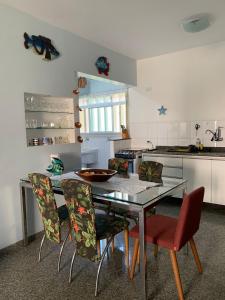 cocina con mesa de comedor y sillas en Apartamento a 50m da areia - Praia da Tabatinga en Caraguatatuba