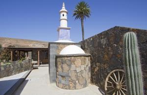 a mosque and a cactus next to a stone wall at Villa Remedios in Teguise