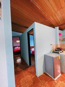 una habitación con una pared blanca y una habitación con cama en Casa hospedaje Puyo, en Puyo