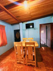 a wooden table and chairs in a room with a tv at Casa hospedaje Puyo in Puyo