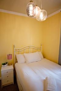 een slaapkamer met een wit bed en 2 verlichting bij Cosy one bedroom flat in city center in Edinburgh