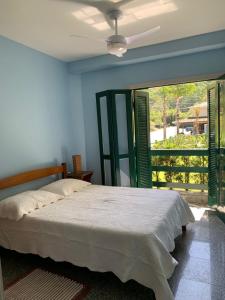 a bedroom with a bed and a ceiling fan at Apartamento a 50m da areia - Praia da Tabatinga in Caraguatatuba