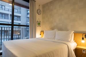 サンパウロにある360 Suítes Vila Mariana - Apartamentos mobiliadosのベッドルーム(大型ベッド1台、大きな窓付)