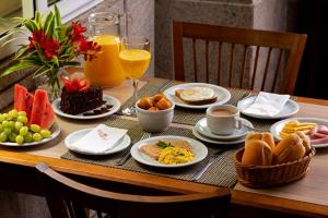 a table topped with plates of breakfast foods and drinks at Hotel Regina Rio de Janeiro in Rio de Janeiro