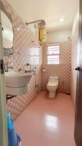 a pink bathroom with a sink and a toilet at Hotel Samrat in Baharampur