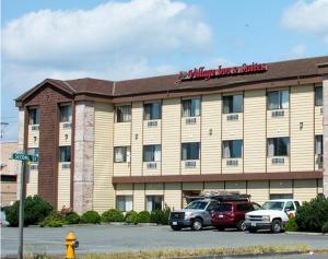 a hotel with cars parked in a parking lot at Village Inn & Suites Marysville in Marysville