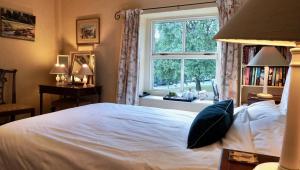 a bedroom with a white bed and a window at Orchard Cottage in Ripon