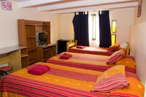 Habitación de hotel con 2 camas y TV en Hostal Residencia Blest Gana, en Viña del Mar