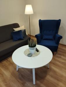 sala de estar con mesa de centro blanca y sofá azul en Havel Apartment en Opole