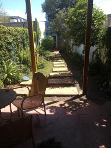 a patio with two chairs and a pathway at Habitaciones en casa encantada para viajeros in Gualeguaychú