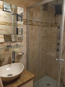 y baño con ducha acristalada y lavamanos. en Elegante departamento, lavadora, sauna, jacuzzi, en Quito