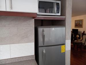 y cocina con microondas y nevera. en Elegante departamento, lavadora, sauna, jacuzzi, en Quito