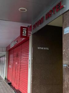una tienda con puertas de garaje rojas y un cartel en SOTAM HOTEL, en Fernandópolis