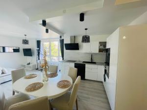 a kitchen and dining room with a white table and chairs at Appartement Charmant Cocon Plus in Croix