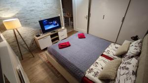 a small bedroom with a bed and a flat screen tv at Cozy, Nice & Quiet apartment Lucky Sarajevo - Free public parking in Sarajevo