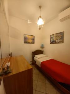 1 dormitorio con 1 cama y escritorio con manta roja en Mini appartamento vicino Roma, en Fiano Romano