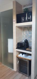 a kitchen with a counter with a microwave on a shelf at Isabel Guest House in Almada