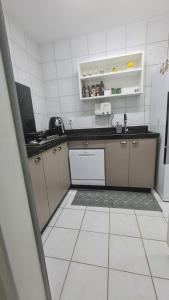 a kitchen with a white tiled floor and a counter at Apartamento: Acomodação mobiliada e completa in Blumenau