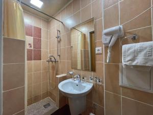 ein Bad mit einem Waschbecken und einem Spiegel in der Unterkunft Hotel Gloria Standard in Borovoye