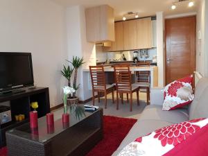 a living room with a couch and a kitchen at DEPARTAMENTO EN RESORT LAGUNA DEL MAR in La Serena