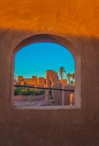 a view of a castle through a window at Gîte Ait lmaalam chez Ahmed in Skoura