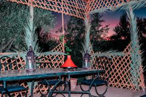 a table with chairs and a red lamp on it at Gîte Ait lmaalam chez Ahmed in Skoura