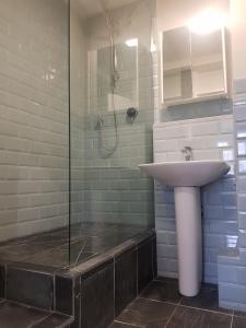 a bathroom with a sink and a shower at Beautiful 3-bedroom flat with stunning views in London