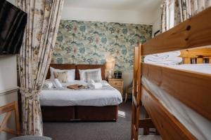 a bedroom with a bed and a bed and curtains at The George Inn in Warminster