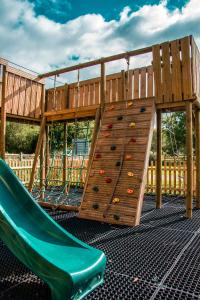 un parque infantil con un tobogán y un muro de escalada en The George Inn, en Warminster