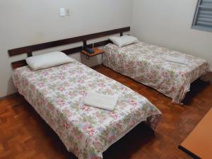 two beds sitting in a room with at SOTAM HOTEL in Fernandópolis
