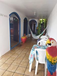 a parrot statue sitting on a table in a room at Pousada Princesa do Mar in Tamandaré