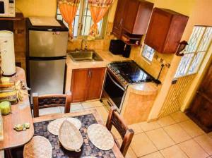 Una pequeña cocina con una mesa y un refrigerador. en Casita Bonita, en Mazatlán 15 fotos más