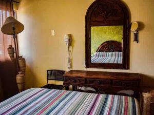 Un dormitorio con una cama, una cómoda y un espejo. en Casita Bonita, en Mazatlán