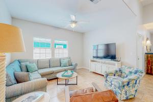 a living room with a couch and a tv at Morgan Shores in Port Aransas