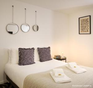 1 dormitorio con 1 cama con 2 espejos en la pared en Almoura Ladeira, en Évora