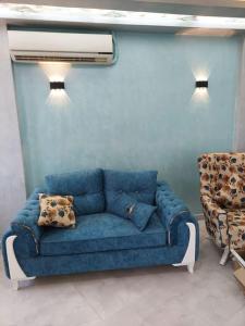 ein blaues Sofa in einem Zimmer mit blauer Wand in der Unterkunft Stunning river view from a spacious 3-Bedroom Apt. in Kairo