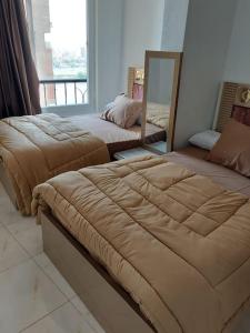 2 Betten in einem Zimmer mit Fenster in der Unterkunft Stunning river view from a spacious 3-Bedroom Apt. in Kairo