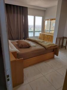 ein großes Bett in einem Zimmer mit einem großen Fenster in der Unterkunft Stunning river view from a spacious 3-Bedroom Apt. in Kairo